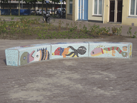 907365 Afbeelding van een door schoolkinderen ontworpen mozaïekbank, op het heringerichte pleintje voor de Basisschool ...